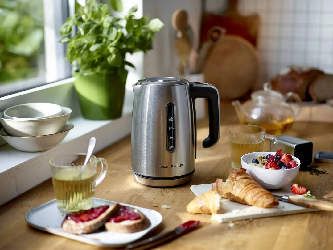 Bouilloire électrique en acier inoxydable sur table de cuisine, petit déjeuner.