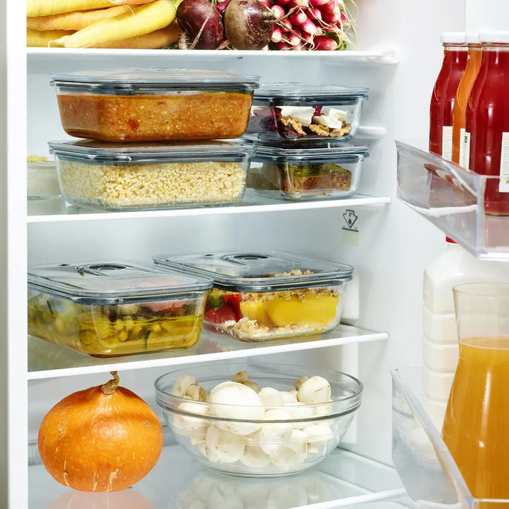 Réfrigérateur rempli de plats préparés et de légumes.