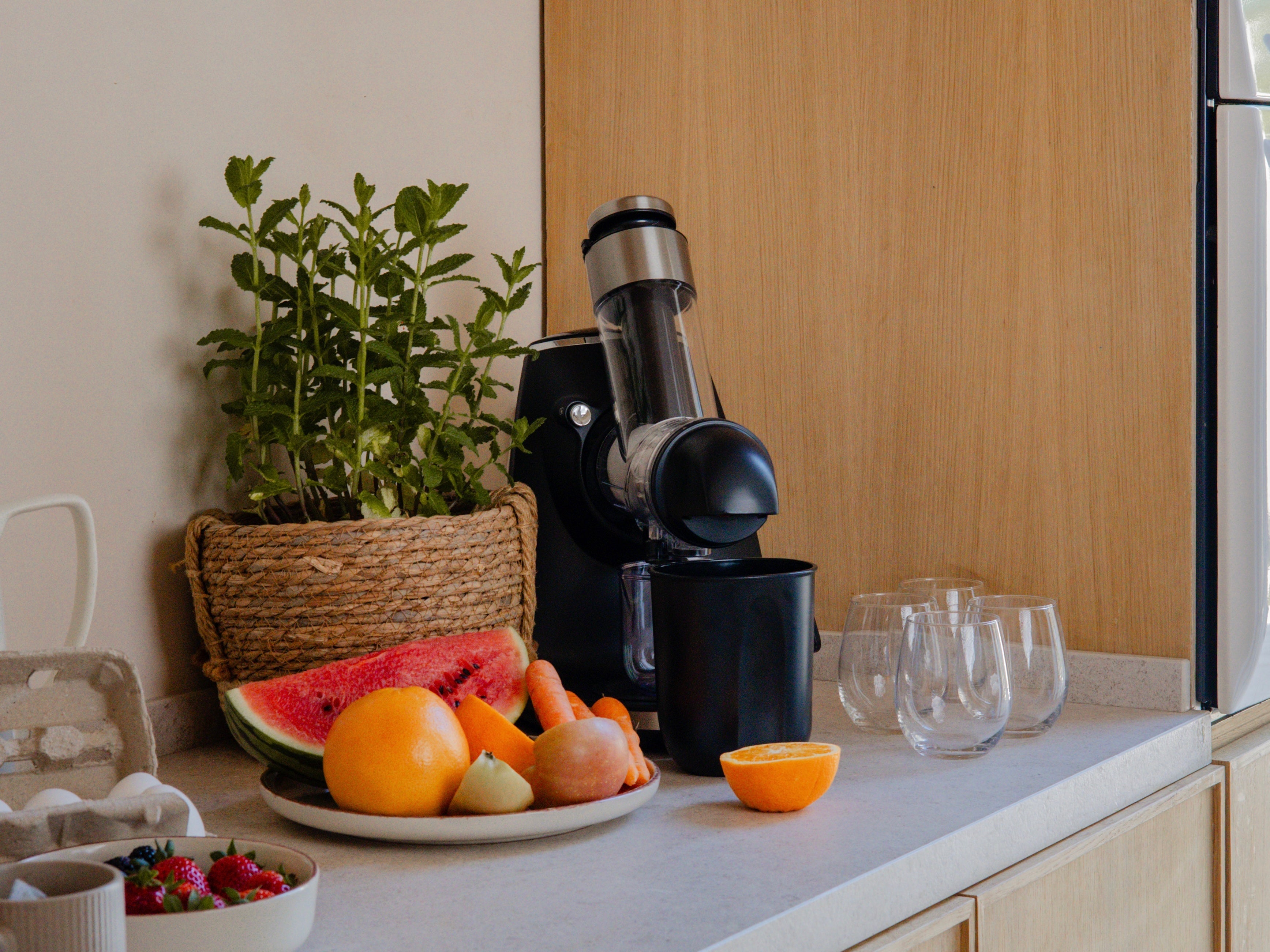 Extracteur de jus riviera&bar avec carafe de jus frais et fruits posés autour