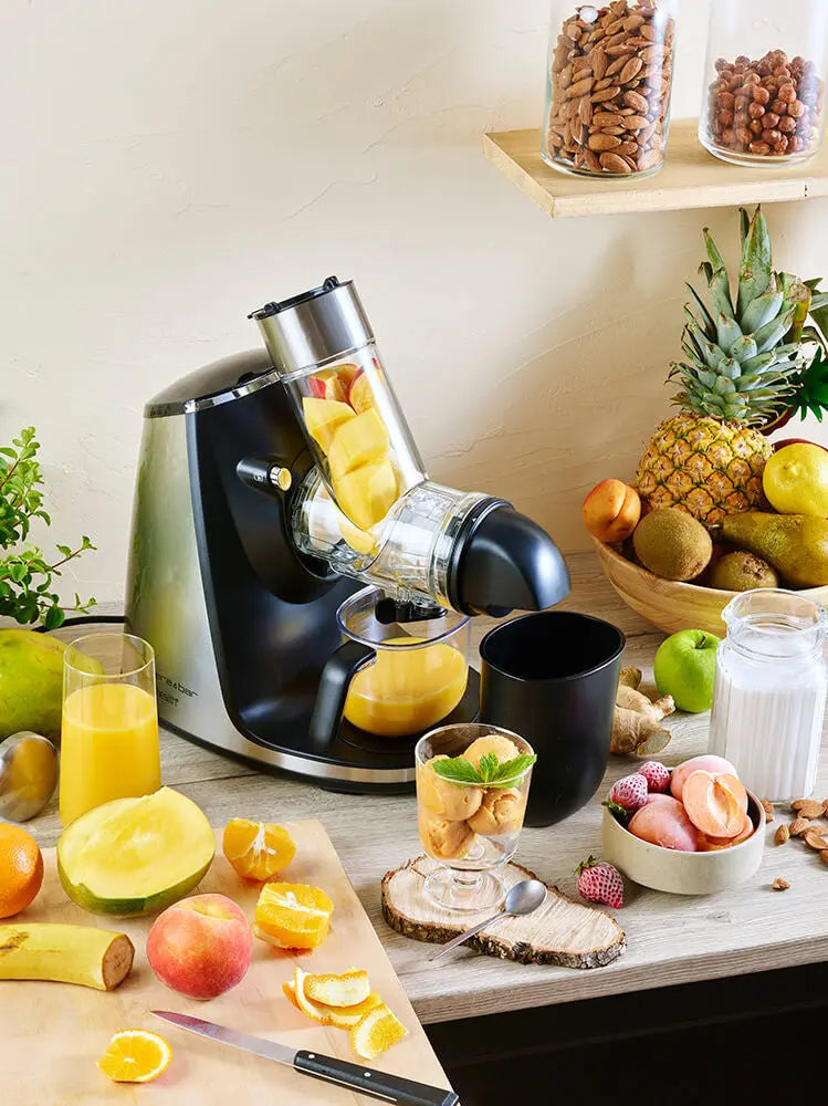 Extracteur de jus riviera&bar avec carafe de jus frais et fruits posés autour