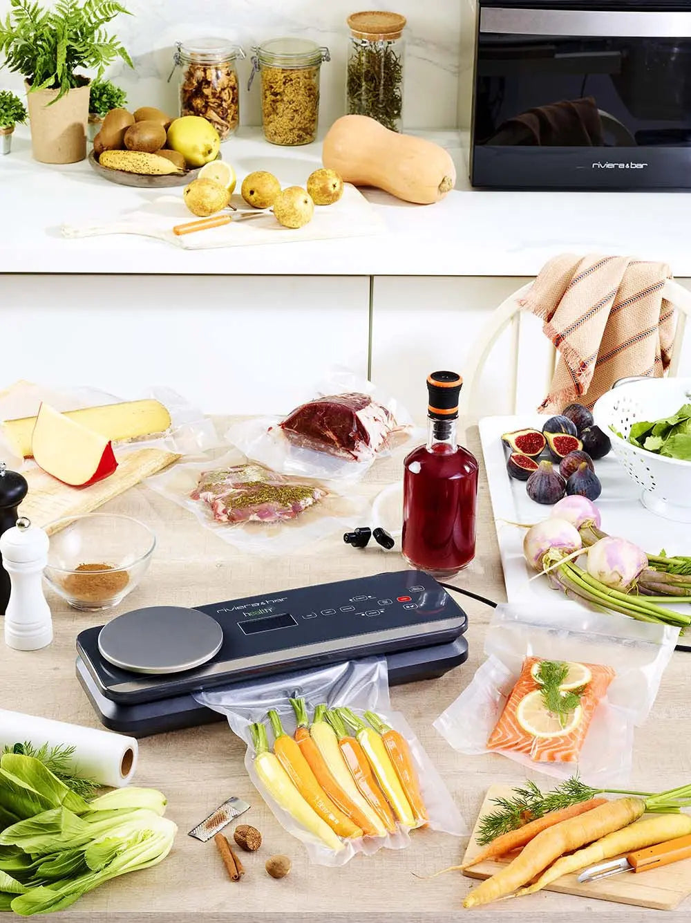 Table de cuisine avec aliments emballés sous vide, machine à sceller, légumes et fruits.