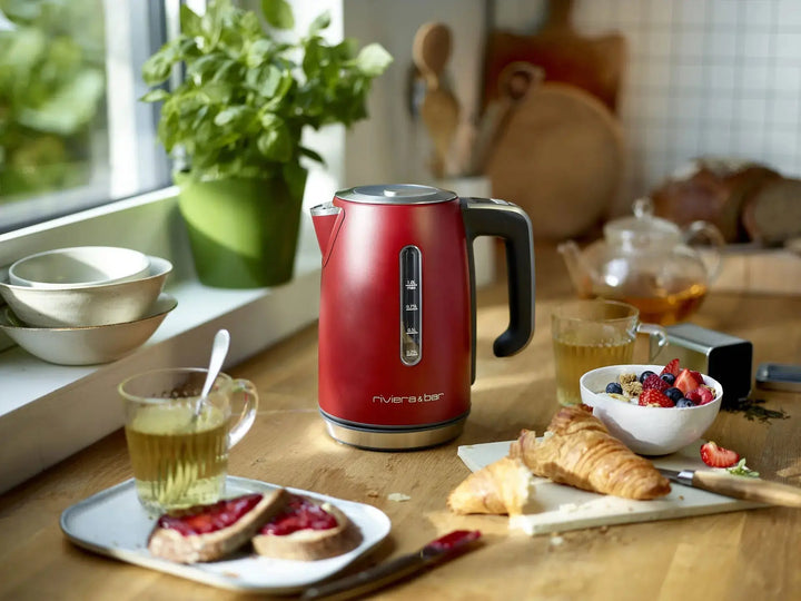 Bouilloire rouge sur table de petit-déjeuner.
