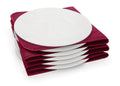Assiette blanche sur tissu bordeaux.