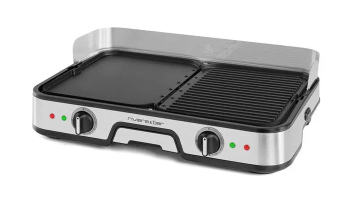 La plancha-gril Combiné riviera&bar se caractérise par un design en acier inoxydable, deux plaques en aluminium (plancha plate à gauche, gril strié à droite), deux boutons de commande, des voyants lumineux et une protection transparente contre les éclaboussures à l'arrière.