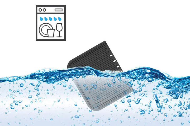 Un plancha-gril riviera&bar Combiné noir et gris est partiellement immergé dans de l'eau bouillonnante, avec un symbole de compatibilité avec le lave-vaisselle au-dessus pour indiquer que l'appareil est compatible avec le lave-vaisselle.
