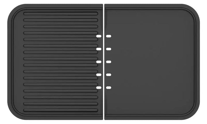 Tapis rectangulaire noir en silicone pour le séchage de la vaisselle, conçu par riviera&bar, avec une disposition en deux parties : un côté avec des crêtes surélevées pour le séchage d'articles tels que le Combiné plancha-gril, et l'autre côté plat avec des fentes de drainage entre les deux sections.
