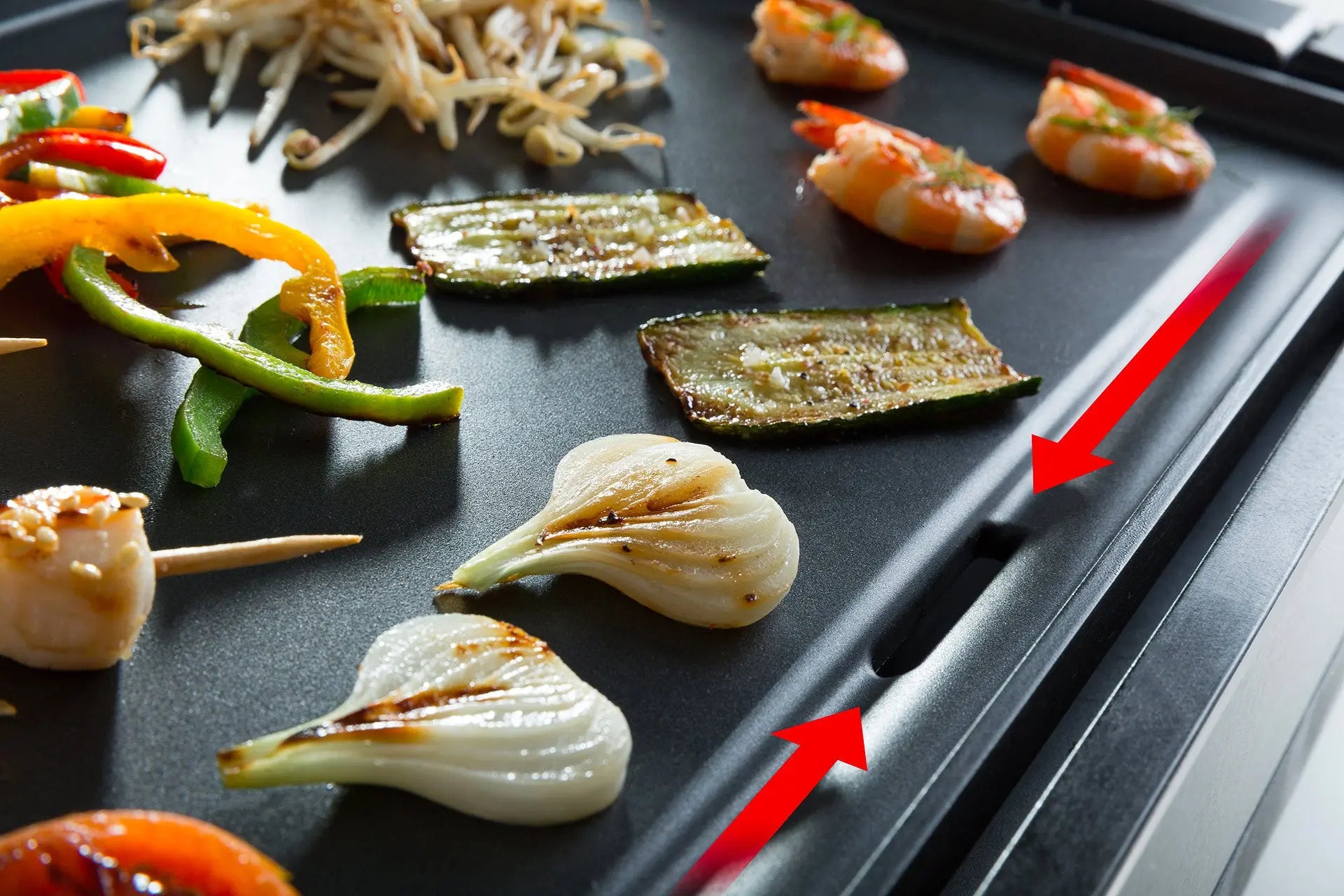 Plancha avec crevettes, courgettes, oignons et légumes.
