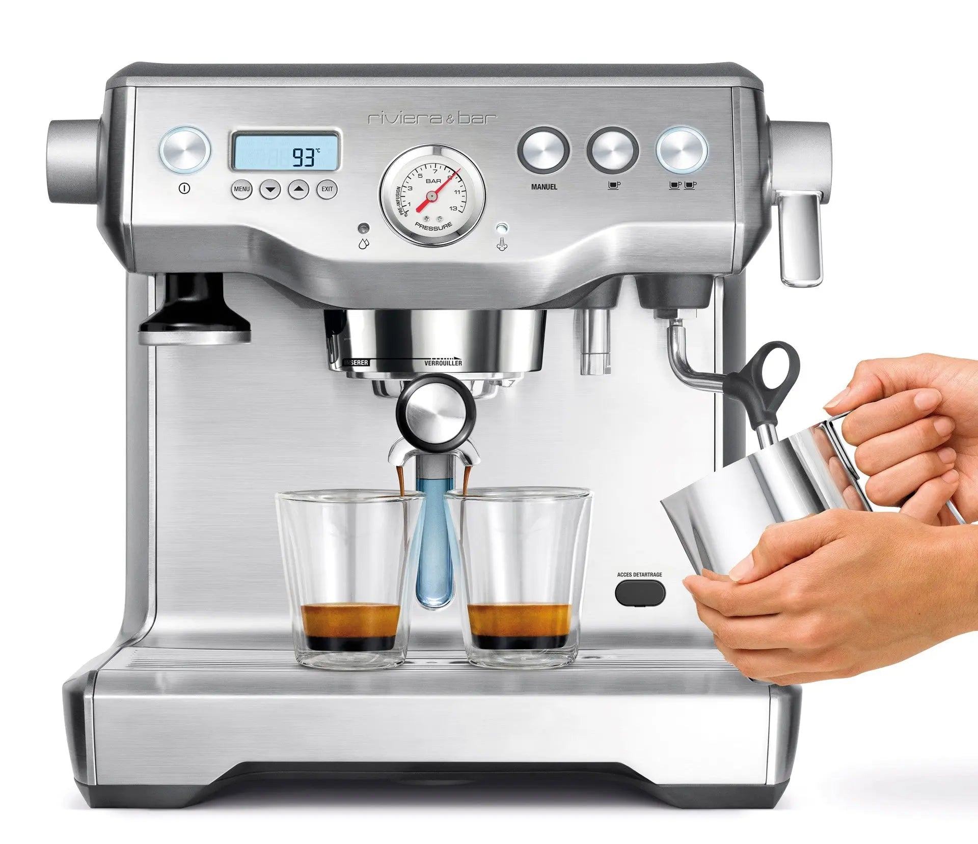 Machine à expresso Riviera & Bar en inox avec écran, manomètre et deux tasses remplies de café, préparation de mousse de lait par une main.