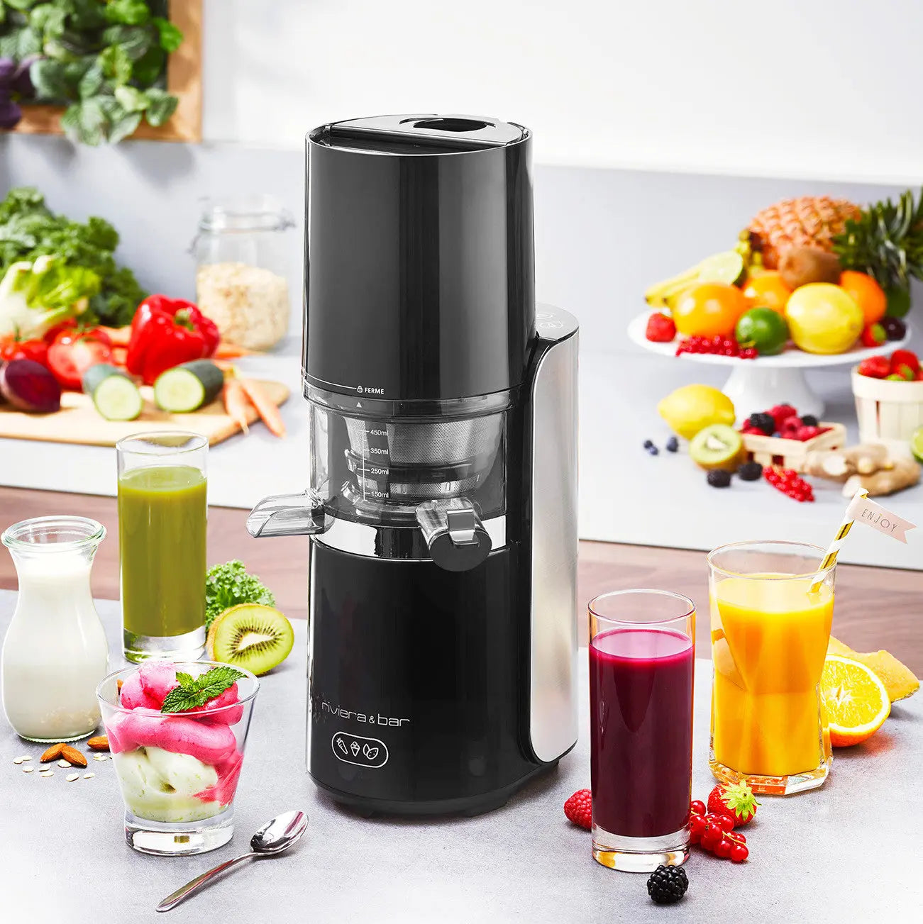 Extracteur de jus noir et argent, fruits et légumes frais.
