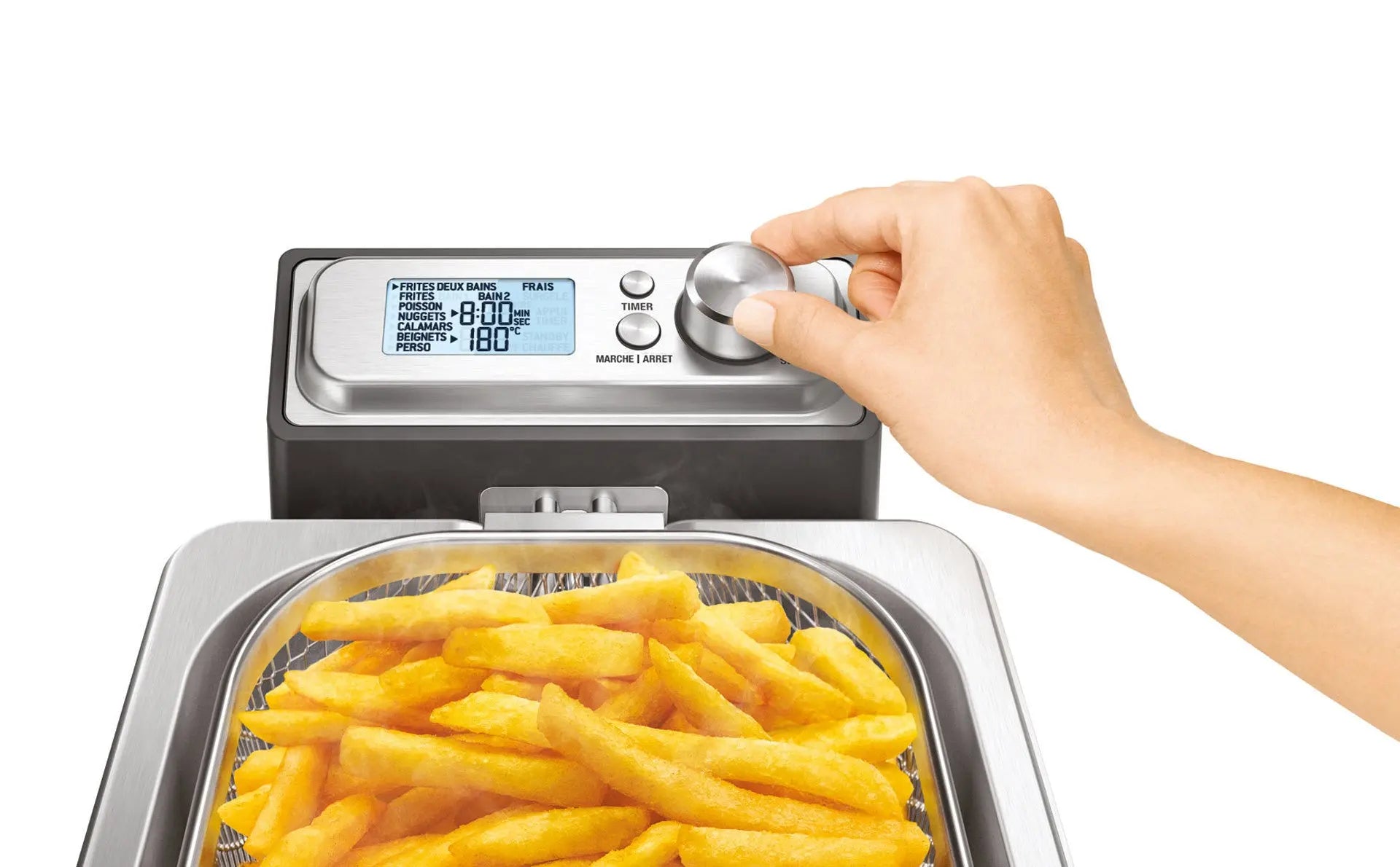 Friteuse avec frites, main ajustant le bouton.