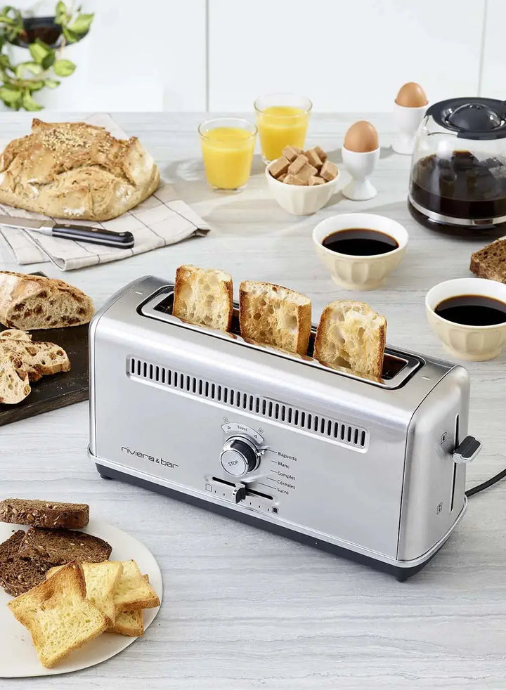Toaster en acier inoxydable, pain, café, jus d'orange.
