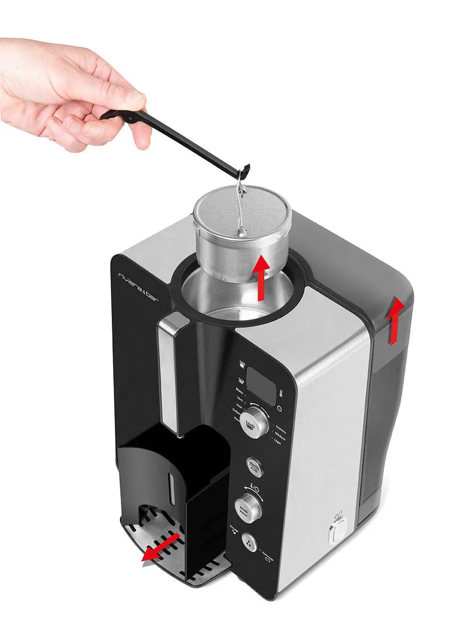 Cafetière argentée et noire avec accessoires et main tenant une tige.