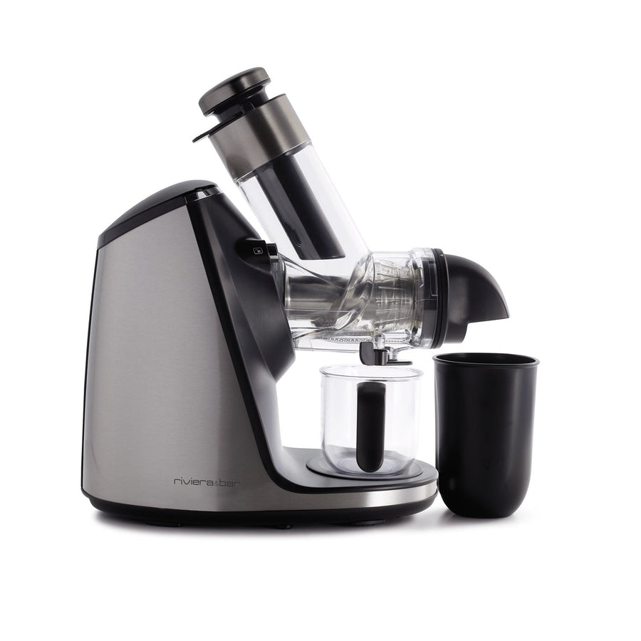 L'Extracteur de jus haute performance de riviera&bar est doté d'un design inox, d'une goulotte transparente, d'accents noirs et d'un gobelet de récupération sur fond blanc - idéal pour une extraction à froid sans effort.