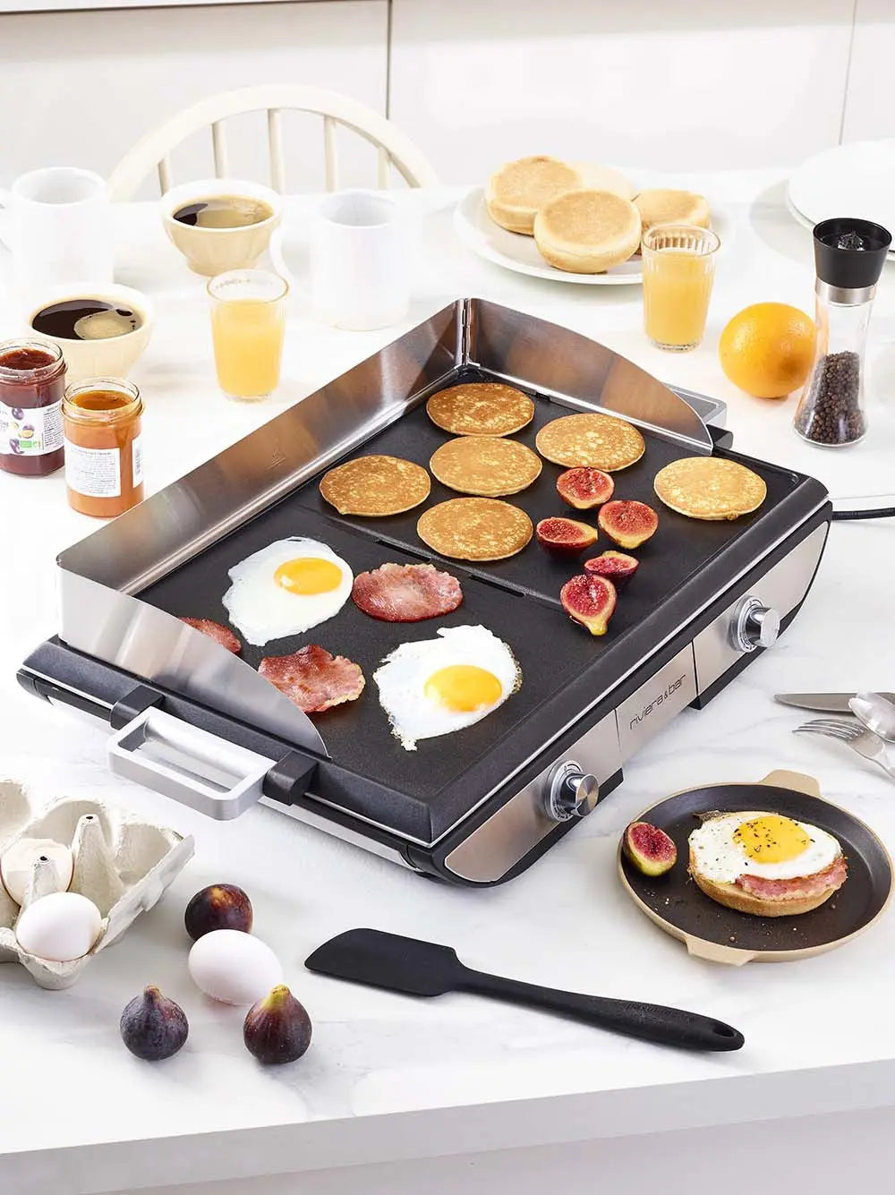 Petit déjeuner avec crêpes, œufs et bacon sur plancha électrique.