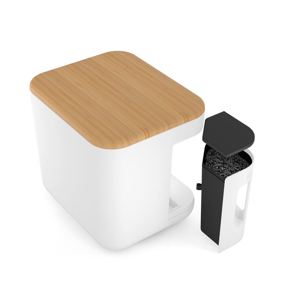 Un bac à litière moderne, blanc et carré avec un couvercle en bois est présenté. A côté, le riviera&bar Composteur de cuisine Minska, un conteneur amovible noir et blanc idéal pour un style de vie cuisine zéro déchet.