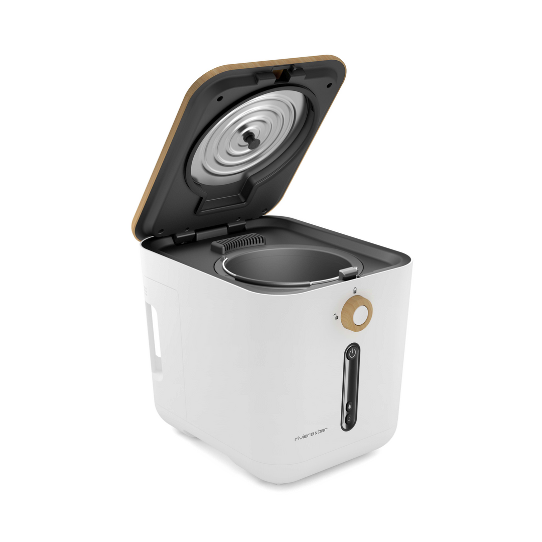 Le Composteur de cuisine Minska de riviera&bar est un composteur de comptoir blanc élégant avec un couvercle ouvert, révélant son récipient intérieur en métal - idéal pour une cuisine zéro déchet et présenté en angle sur un fond blanc.