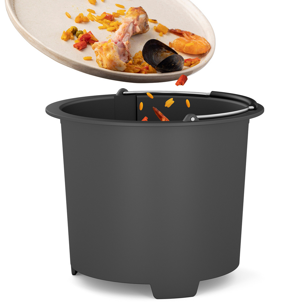 Une assiette contenant des restes de nourriture - os de poulet, riz et coquille de moule - est vidée dans le Composteur de cuisine Minska by riviera&bar, soutenant un mode de vie de cuisine zéro déchet.