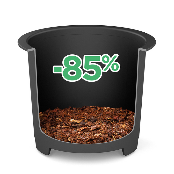 Un pot de fleurs noir avec de la terre affiche un grand vert -85% au-dessus de lui, mettant en évidence jusqu'à 85% de déchets en moins avec le Composteur de cuisine Minska de riviera&bar pour une cuisine zéro déchet.