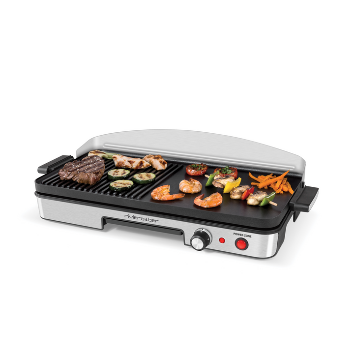 Le Plancha-gril Power zone QPL 365 de riviera&bar dispose de deux zones de chauffe, de surfaces en acier inoxydable striées et plates, d'un couvercle et d'un bouton de contrôle rouge Power zone pour griller steak, poulet, crevettes, légumes et frites de patates douces.