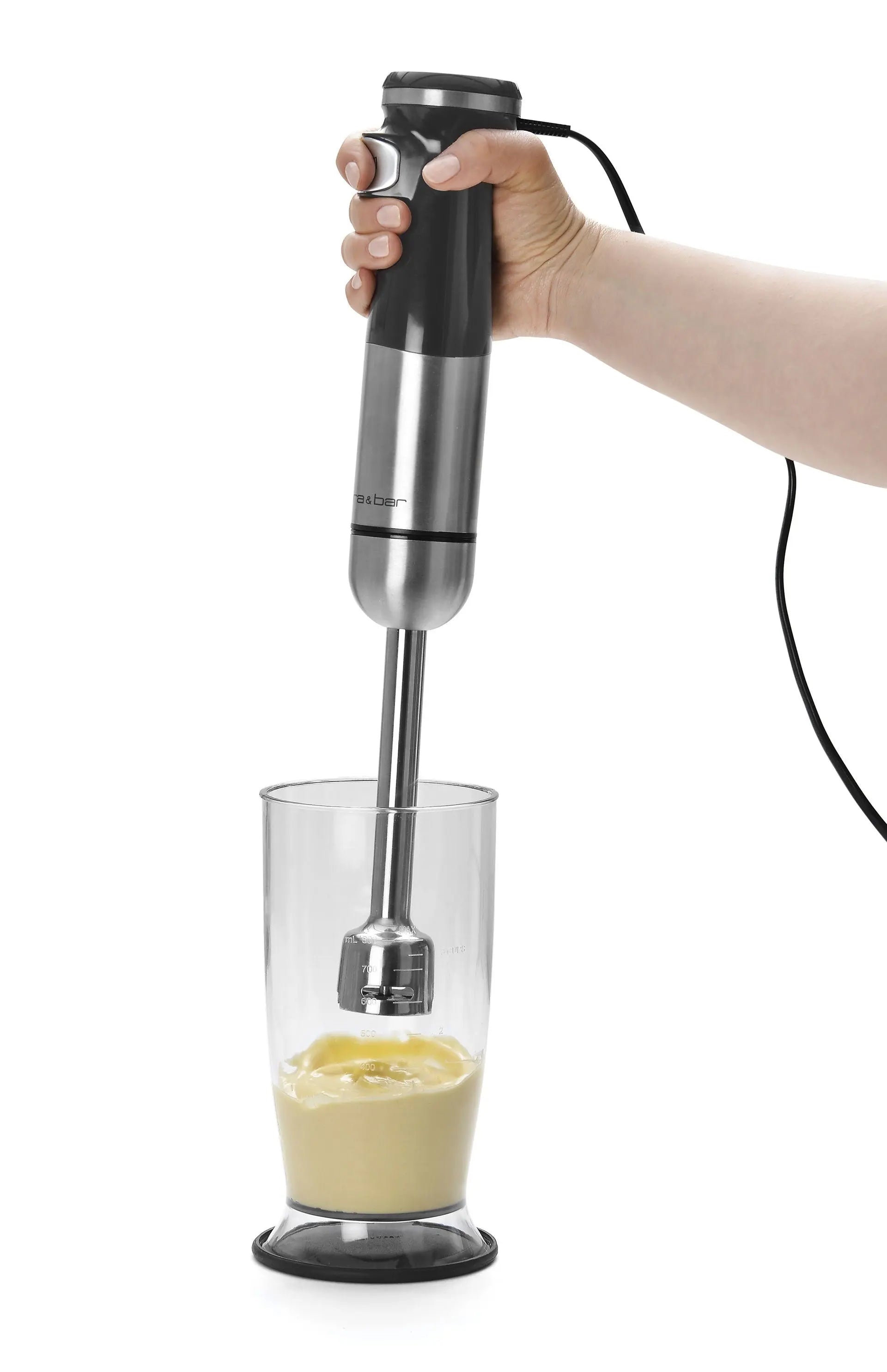 Mixeur plongeant en acier inoxydable et noir utilisé dans un verre.