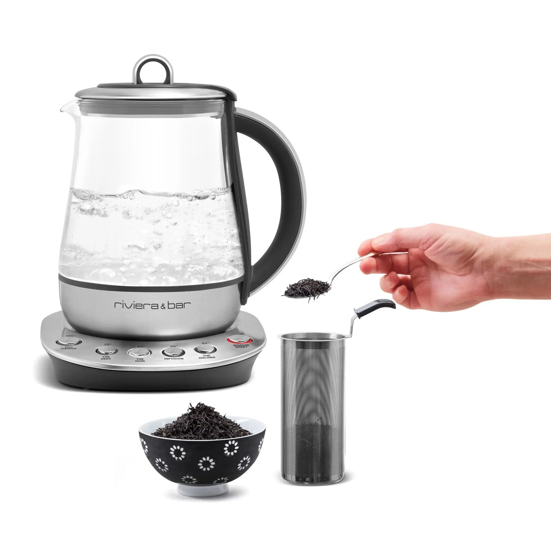 Bouilloire électrique en verre avec infuseur à thé et main versant du thé en vrac.