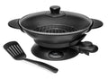 Wok électrique noir avec couvercle en verre et spatule.