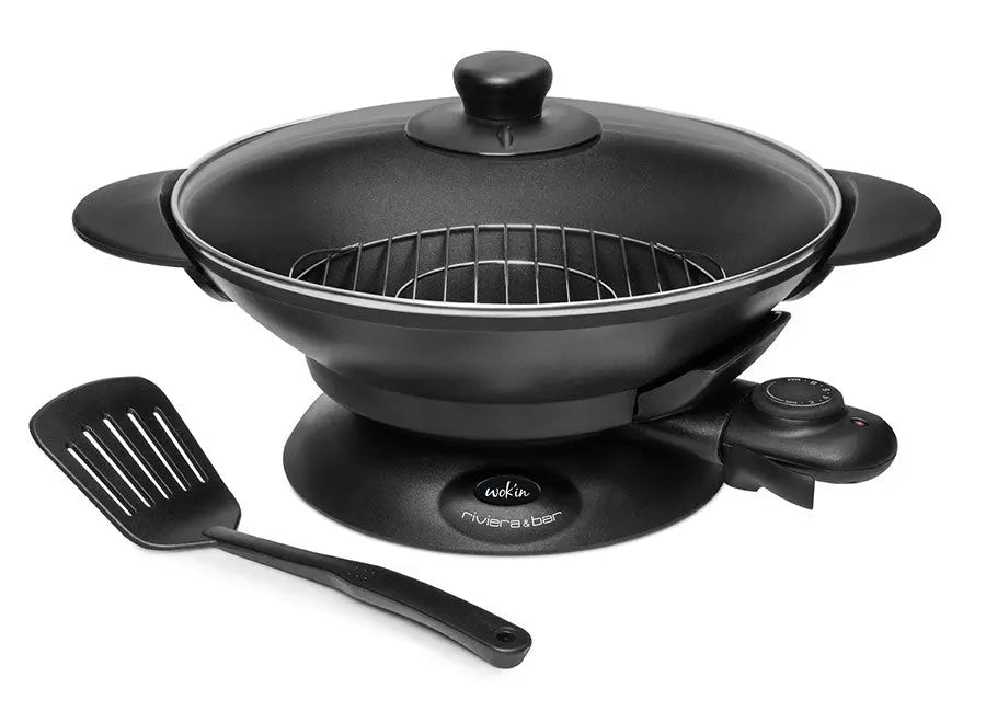 Wok électrique noir avec couvercle en verre et spatule.