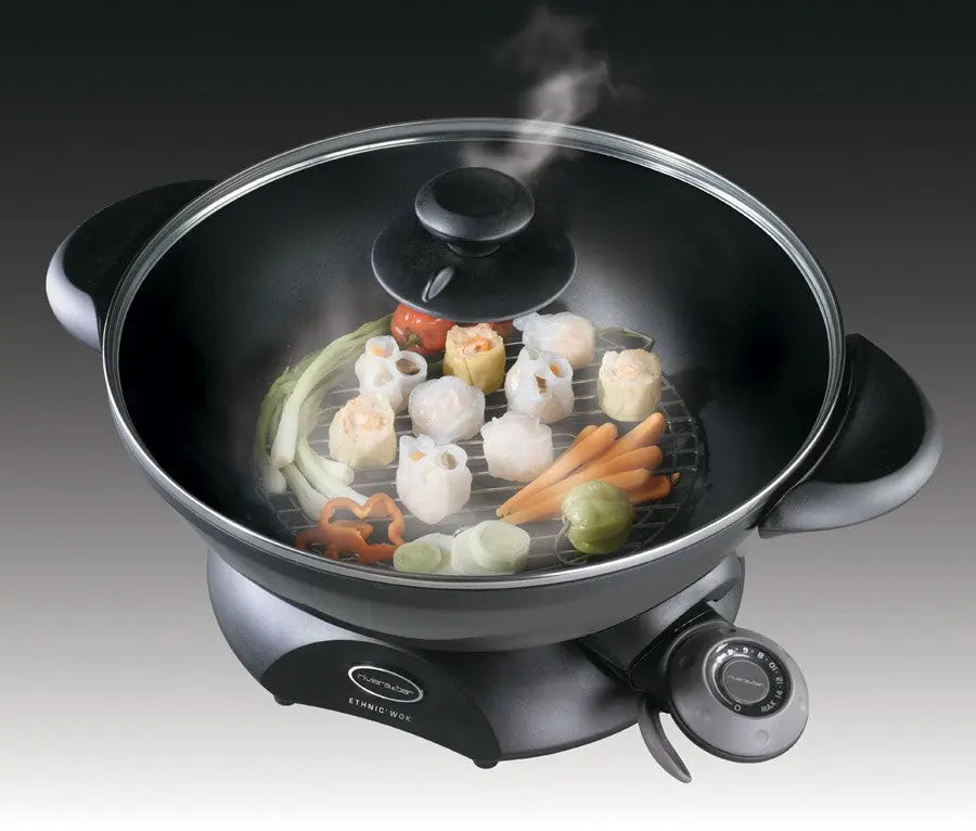 Wok électrique avec couvercle en verre et légumes.